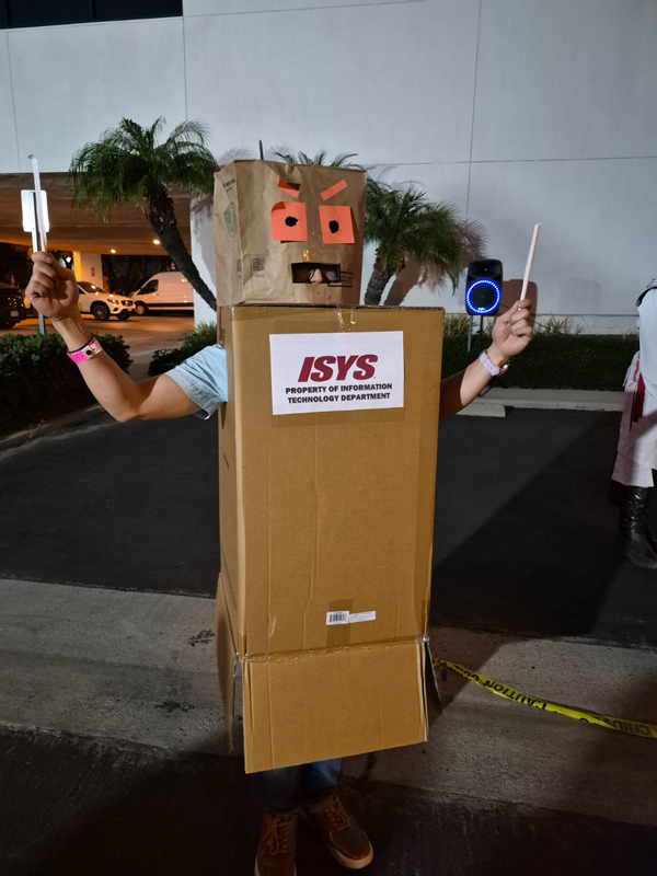 Johnny Lee, winner of the ISYS Trunk or Treat 2025 costume contest, wearing a creative robot costume made from cardboard boxes labeled “ISYS Property of Information Technology Department.”