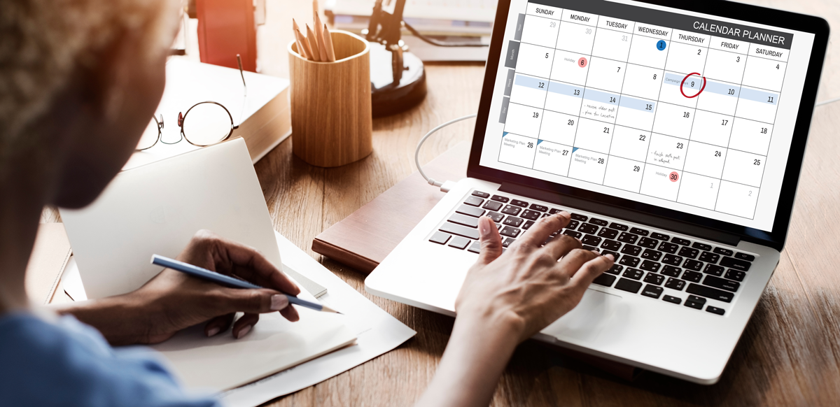 Professional reviewing a digital calendar timeline on a laptop while planning early intervention activities for workers’ compensation claims and nurse case management coordination.