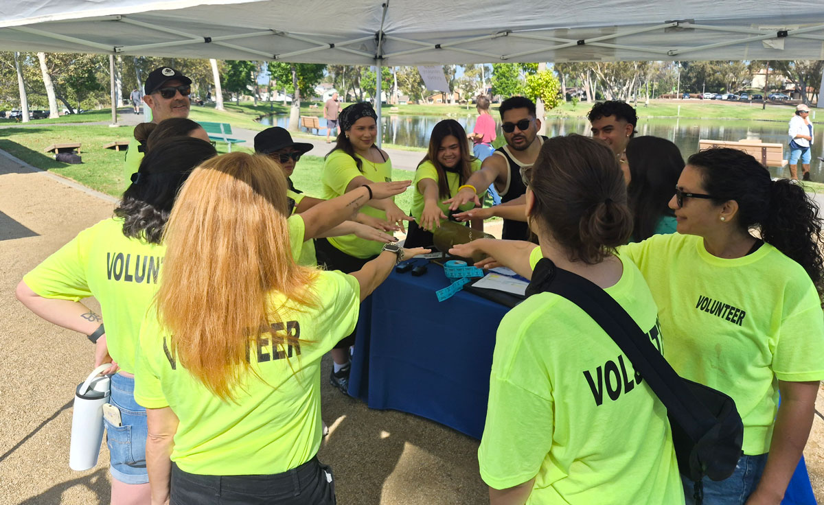 ISYS® Summer Picnic volunteers gather for a team huddle at the event check-in table.