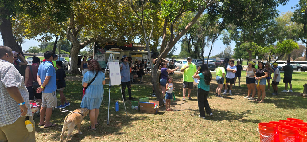 ISYS® employees, families, volunteers, and pets gather near The Habit food truck during the 2026 Summer Picnic.