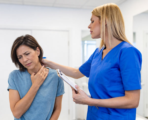Injured worker with shoulder pain speaking with a nurse case manager during a workers’ compensation consultation.